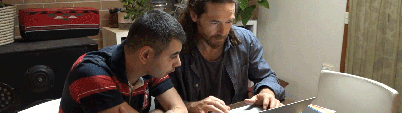 A young man and support worker at a computer